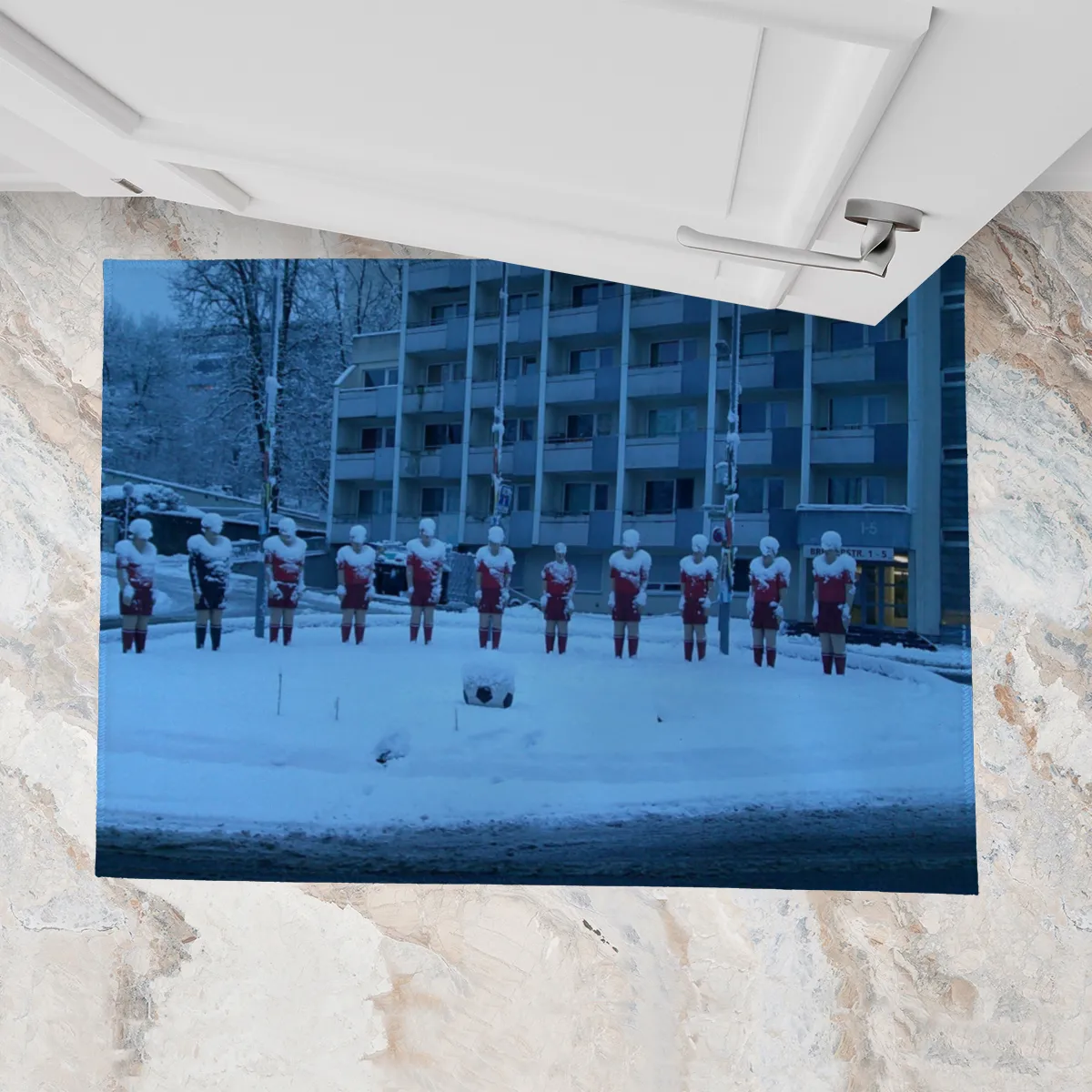 Fußmatte Fußball-Skulpturen im Schnee in der Morgendämmerung